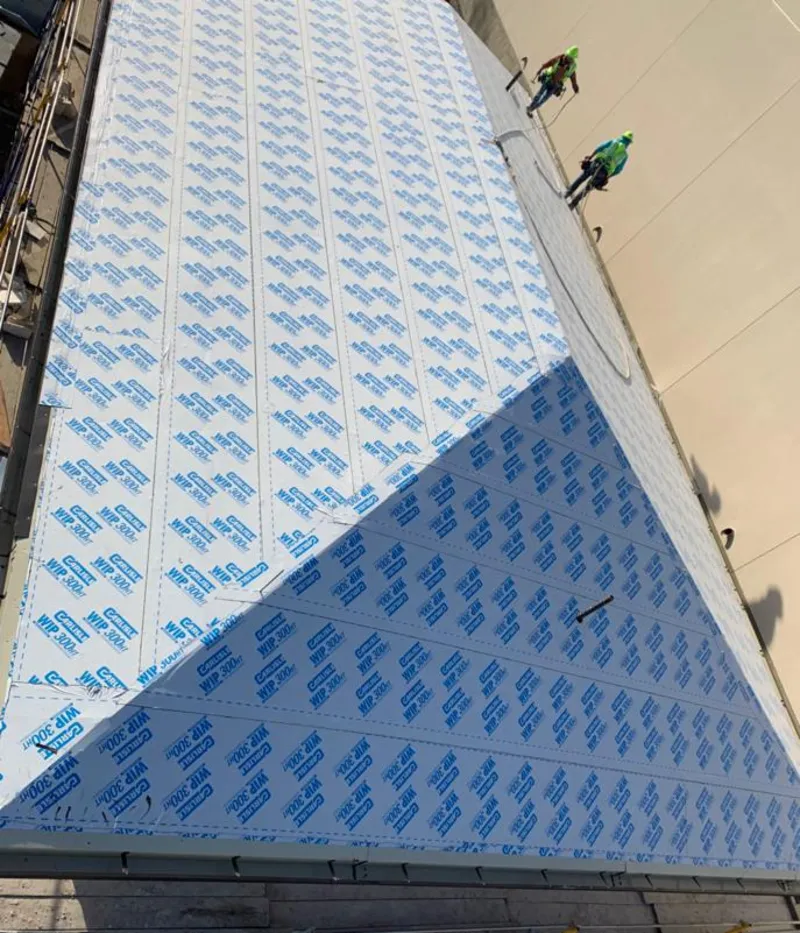 Professional roofers installing underlayment on a metal roof in Forest Grove